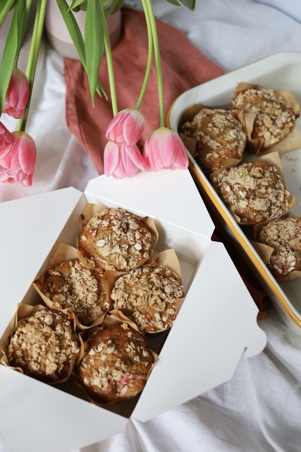 Homemade muffins packed in a box with pink tulips